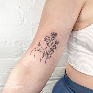 Beautiful fine line tattoo by Chloe Mickham featuring a woman intertwined with nature and flowers. A stunning and delicate design.