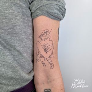 Fine line and illustrative style tattoo of a loving mother embracing her child, symbolizing family and connection. By Chloe Mickham.