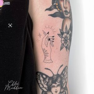 Get a unique illustrative tattoo of a hand holding a pencil, expertly done in fine line style by Chloe Mickham.