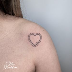 Elegant fine line heart tattoo with intricate embroidery details, perfectly executed by Chloe Mickham.
