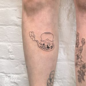 Enjoy a cup of creativity with this elegant tea pot tattoo, expertly executed by Chloe Mickham in fine line illustrative style.