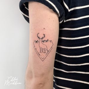 Elegant fine line tattoo by Chloe Mickham featuring a geometric deer nestled among majestic mountains.