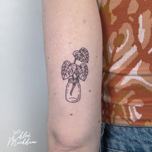 Illustrative tattoo featuring a monstera plant in a vase or mason jar, by Chloe Mickham.