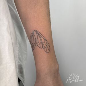 Elegant and intricate fine line wings tattoo design crafted by Chloe Mickham, showcasing grace and freedom. Perfect for those seeking a delicate and unique tattoo.