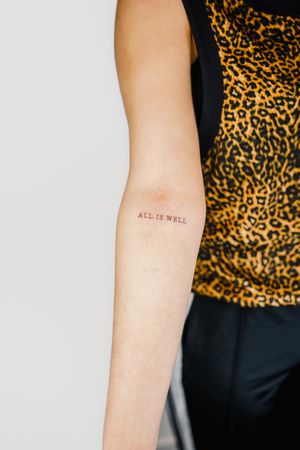 Simple and elegant small lettering quote tattoo on forearm by Gabriele Edu