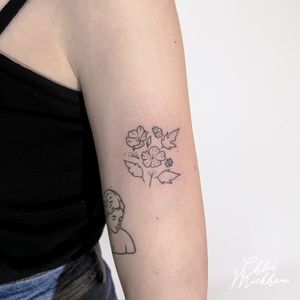 Elegant and intricate fine line tattoo featuring a delicate design of flowers and leaves, expertly done by talented artist Chloe Mickham.