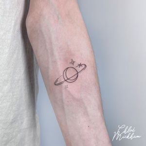 Elegant and intricate fine line tattoo featuring a moon, planet, and star motif by talented artist Chloe Mickham.
