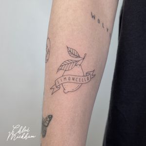 Stunning fine line tattoo of a vibrant lemon, created by talented artist Chloe Mickham. Perfect for fruit lovers!