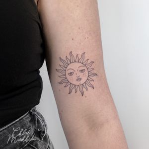 Experience the delicate beauty of Chloe Mickham's fine line tattoo featuring a stunning sun motif. Perfect for those seeking a minimalist yet impactful design.