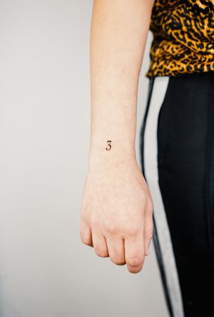 Small lettering number tattoo on forearm by Gabriele Edu. Simple yet meaningful design.