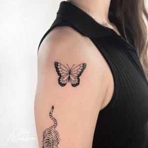 Discover the beauty of fine line art with this stunning butterfly motif tattoo designed by Chloe Mickham.