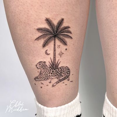 Capture the wild spirit with this illustrative tattoo by Chloe Mickham, featuring a leopard and palm tree in delicate fine line style.