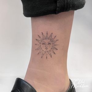 Get your daily dose of sunshine with this fine line sun tattoo by the talented artist Chloe Mickham. Simple yet elegant design perfect for subtle body art.