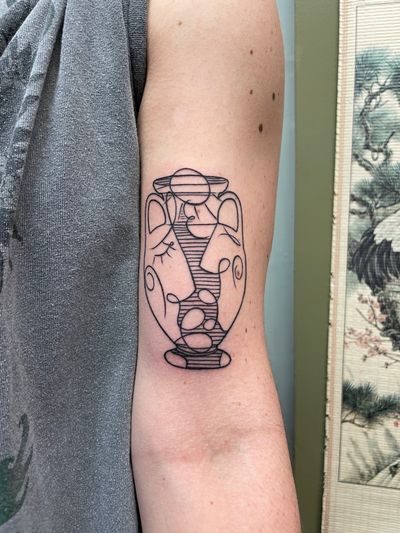 Fine line upper arm tattoo by Ermis Atzemoglou featuring a unique design of people, vase, and kiss motifs.