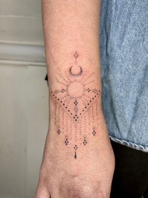 Experience the celestial beauty of a hand-poked dotwork tattoo featuring a radiant sun and intricate patterns, by Indigo Forever Tattoos.