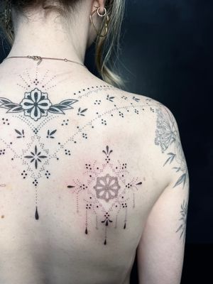 Elegant hand-poked design on upper back, featuring intricate floral patterns by Indigo Forever Tattoos.