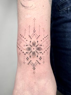 Beautiful floral and ornamental design on forearm by Indigo Forever Tattoos, done in hand-poked style.