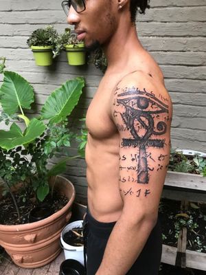Unique blackwork design with small lettering, beautifully placed on the upper arm to symbolize protection and healing from the ancient Egyptian Eye of Horus.