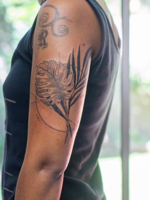 Fine line illustrative tattoo by Nikki Bostin, featuring a beautiful monstera plant design on the upper arm.
