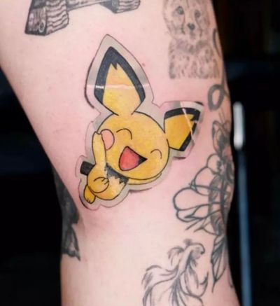 Get inked with a cute Pikachu tattoo design featuring sticker accents and adorable ears, by tattoo artist Nikki Bostin.