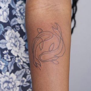 Elegantly detailed lower arm tattoo by Nikki Bostin featuring graceful koi fish and intricate figures.
