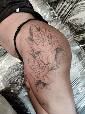 Elegant blackwork flower tattoo on upper leg by Mary Shalla, showcasing intricate details and bold lines.