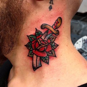 Stunning traditional tattoo featuring a flower and sword motif, executed by the talented Alessandro Lanzafame.