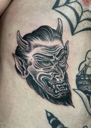 Get a fierce Japanese devil tattoo on your ribs by the talented artist Alex Travers. Embrace the dark side with this striking design.