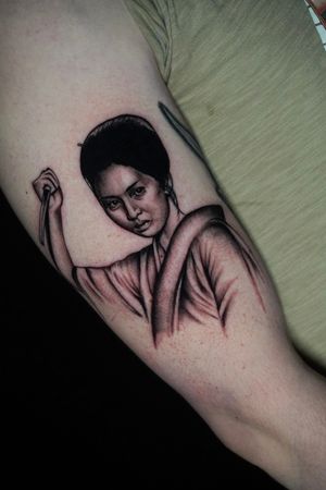 Experience the elegance of a blackwork and realism geisha tattoo by Miss Vampira, beautifully placed on your upper arm.