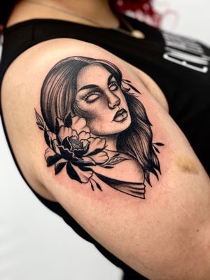 Adorn your upper arm with a stunning blackwork tattoo featuring a beautiful flower and woman design by the talented artist, Miss Vampira.