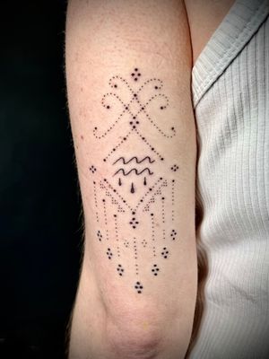 Get mesmerized by this intricate hand-poked pattern of waves on your upper arm by Indigo Forever Tattoos.