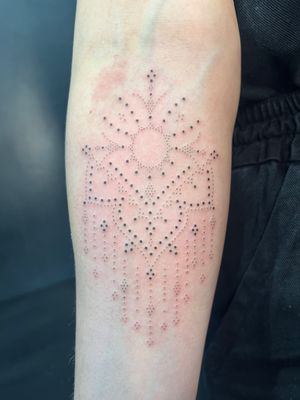 Get a stunning hand-poke mandala pattern tattoo by Indigo Forever Tattoos on your forearm. Elevate your style with intricate design.