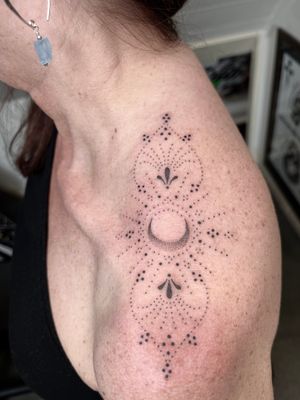 Get a stunning hand-poked ornamental moon and mandala design by Indigo Forever Tattoos on your shoulder. Stand out with this unique piece of body art.