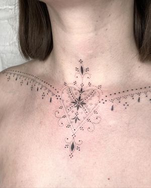 Intricate ornamental design with heart motif by Indigo Forever Tattoos, perfect for chest placement.