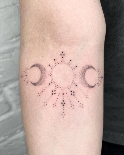 Experience the magic of the sun and moon in this stunning hand-poke ornamental design by Indigo Forever Tattoos.