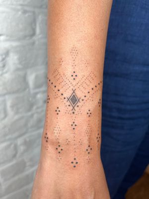Experience the intricate beauty of hand-poked dotwork by Indigo Forever Tattoos. This ornamental design will surely make a statement.