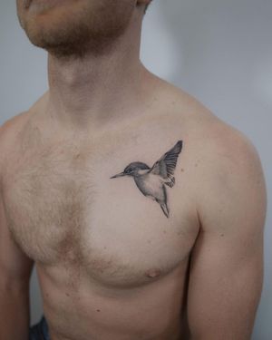 Experience intricate micro realism by El Bernardes with a stunning black and gray hummingbird tattoo on your chest.