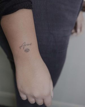 Small lettering tattoo on forearm featuring an eye, name, and text. Expertly done by El Bernardes.