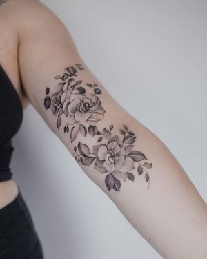 Elegant floral design by El Bernardes featuring intricate dotwork and fine line details. Perfect for those wanting a unique and delicate tattoo on their upper arm.