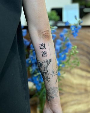 Get a striking blackwork forearm tattoo featuring Japanese kanji and a meaningful quote by talented artist Hana Kaki.