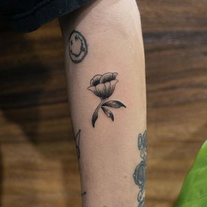 Adorn your upper arm with a stunning blackwork flower tattoo by the talented artist Hana Kaki. Embrace the beauty of simplicity and elegance.