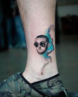 Artemis creates a stunning black and gray micro-realism ankle tattoo featuring a pattern inspired by Mac Miller's music.
