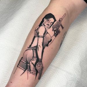 Get a fierce blackwork tattoo of Lara Croft on your forearm by artist Artemis. Embrace your inner warrior!