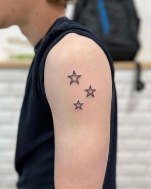 Elegant and bold blackwork stars tattoo by Hana Kaki, perfect for upper arm placement.