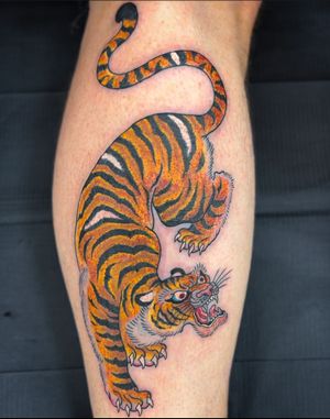 Get fierce with this stunning Japanese tiger tattoo by artist Carlos Zucato, beautifully inked on your lower leg. Embrace the power and strength of the tiger with this intricate and exotic design.