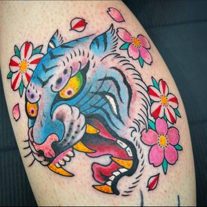 Get inked by artist Carlos Zucato on your lower leg with this striking traditional tiger and flower motif design.