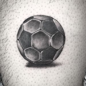 Capture your love for soccer with this striking black and gray tattoo of a soccer ball by renowned artist Carlos Zucato.