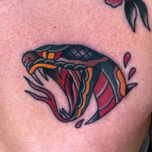 Get inked by the talented Carlos Zucato with this bold traditional snake design on your chest. Stand out with this timeless piece!