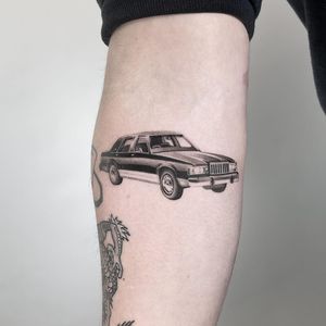 Impressively detailed micro realism car tattoo on upper arm by talented artist Martin Rosenberg.