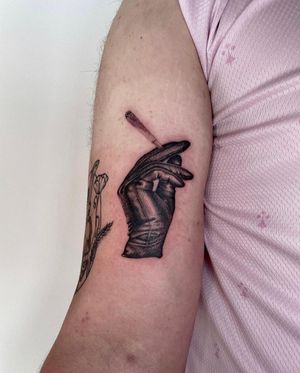 Experience the intricate details of Martin Rosenberg's micro realism style with this hand and gloves tattoo on your upper arm.